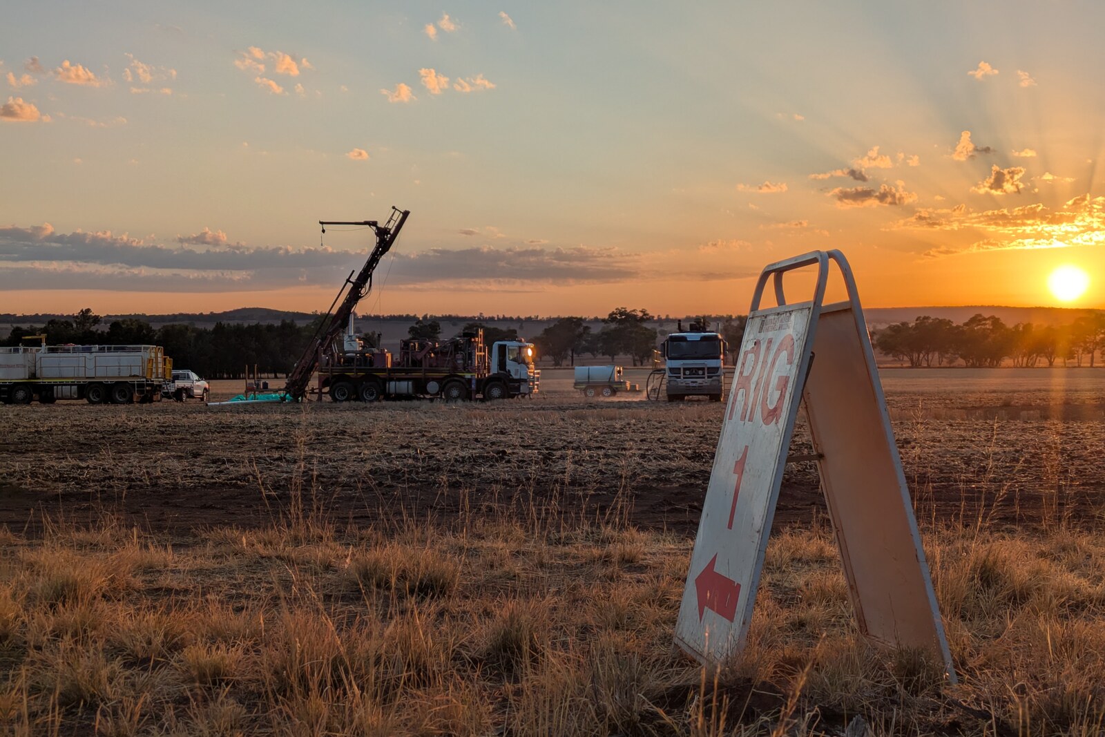 A mineral exploration drill rig on site at dusk